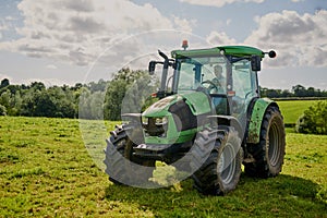 Every farm needs a tractor. Full length shot of a green tractor on an open piece of farmland.