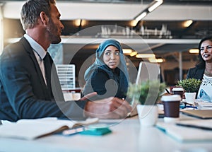 Every idea is worth considering. a diverse group of businesspeople brainstorming around a table in their office.