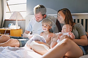 Every moment together is precious. a young family of four bonding in the bedroom.