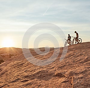 Every ride is a tiny holiday. Full length shot of two young male athletes mountain biking in the wilderness.