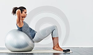 Every workout is a step closer to your goal. a young woman exercising using a fitness ball.