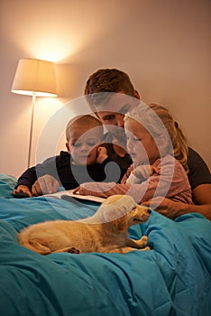 Everybody loves a good story. A father reading a bedtime story to his kids.