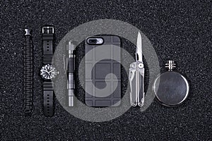 Everyday carry EDC military items for men- multi tool, lighter, phone, tactical watch, survival bracelet,flashlight and flask. photo