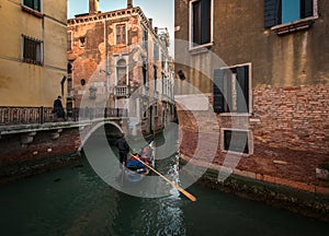 Everyday life of a gondolier. Walking on the bridges of the old city of Venice. Bright sun. The beauty of the ancient city. Italy