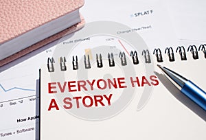 EVERYONE HAS A STORY. Text written on notepad with pen on financial documents