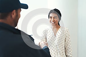 Everyone loves great service. an unrecognizable male courier shaking hands with a female customer.
