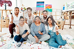 Everyone loves to paint. Full length portrait of a diverse group of friends posing together during an art class in the