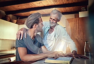 Everyone needs a spiritual mentor. a father and son doing Bible study together at home.