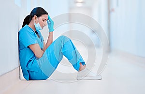 Everyone needs to cry. a young female nurse sitting on the floor looking depressed.