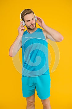 Everyone needs a tune-up. Sportsman listen to music. Sportsman training to tune. Strong sportsman wear headphones and