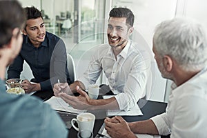 Everyones feeling positive about this meeting. Shot of a group of businessmen having a meeting around a table in an