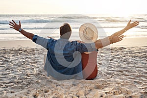 Everything is better with an ocean view. Rearview shot of a middle aged couple sitting on the beach.