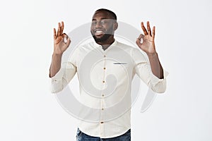 Everything is excellent. Satisfied attractive african american male businessman in white shirt showing okay or ok