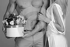 Everything for her. Sexy gift for beautiful woman. 8 march and womans day. Man sexy muscular torso giving bouquet