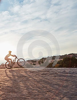 Everything is a lot more beautiful when you go on two wheels. a young man out mountain biking during the day.