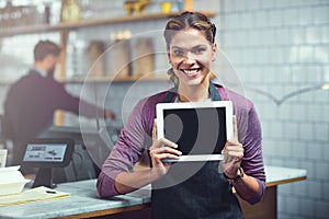 Everything your read on our blog is true. Portrait of a young woman showing a blank screen on a digital tablet in her