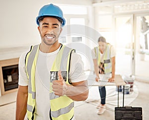 Everythings all going to plan over here. a handsome young construction worker standing inside and making a thumbs up