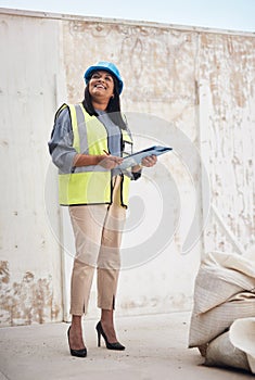 Everythings on schedule. Full length shot of an attractive young female construction worker working on site.