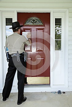 Eviction notice being taped to the door by a law enforcement officer