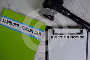 Eviction Notice on Document and Book Landlord-Tenant Law isolated on Wooden Table