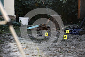 Evidence with yellow CSI marker for evidence numbering on the residental backyard in evening. Crime scene investigation concept