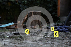 Evidence with yellow CSI marker for evidence numbering on the residental backyard in evening. Crime scene investigation concept