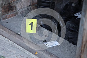 Evidence with yellow CSI marker for evidence numbering on the residental backyard in evening. Crime scene investigation concept