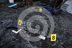 Evidence with yellow CSI marker for evidence numbering on the residental backyard in evening. Crime scene investigation concept