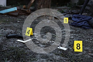 Evidence with yellow CSI marker for evidence numbering on the residental backyard in evening. Crime scene investigation concept