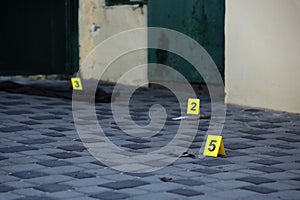 Evidence with yellow CSI marker for evidence numbering on the residental backyard in evening. Crime scene investigation concept