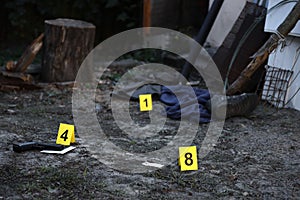 Evidence with yellow CSI marker for evidence numbering on the residental backyard in evening. Crime scene investigation concept