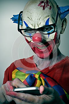 Evil clown using a smartphone