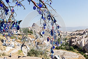 Evil Eye Beads on Tree and Fairy tale chimneys in Guvercinlik Valley photo