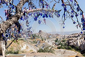 Evil Eye Beads on Tree and Fairy tale chimneys in Guvercinlik Valley photo