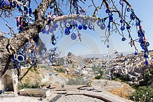 Evil Eye Beads on Tree and Fairy tale chimneys in Guvercinlik Valley photo