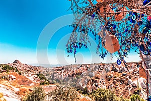 Evil Eye Beads on Tree and Fairy tale chimneys in Guvercinlik Valley photo