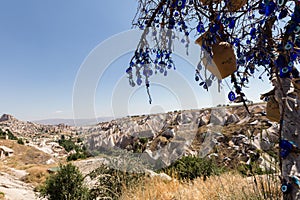 Evil Eye Beads on Tree and Fairy tale chimneys in Guvercinlik Valley photo