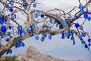 Evil eye in tree behind Uchisar Castle in Cappadocia, Uchisar, Turkey