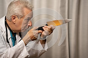 Evil medical doctor holding knife in hand to murder his patients