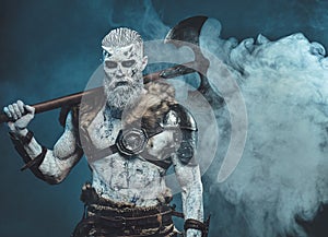 Evil scandinavian warrior with two handed axe on his shoulder