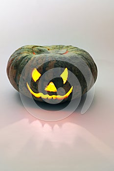 Evil smile of jack olantern. carved face on empty green pumpkin with candle lantern inside