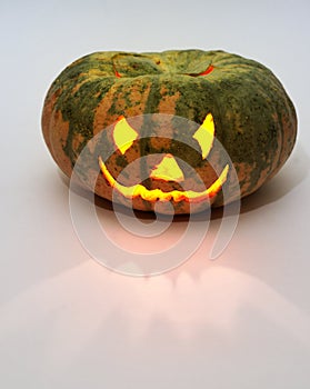 Evil smile of jack olantern. carved face on empty green pumpkin with candle lantern inside. Copy space, with clipping path