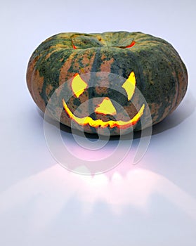 Evil smile of jack olantern. carved face on empty green pumpkin with candle lantern inside. Copy space, with clipping path