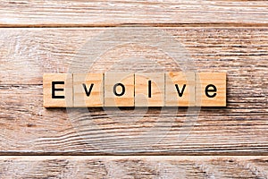 EVOLVE word written on wood block. EVOLVE text on wooden table for your desing, concept