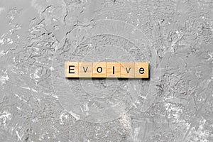 EVOLVE word written on wood block. EVOLVE text on cement table for your desing, concept