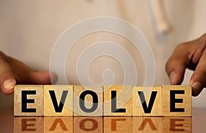 EVOLVE word written on wood block. EVOLVE text on wooden table for your desing, concept
