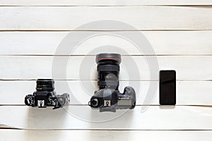 Evolving Technologies Concept. Vintage Film Camera, Digital Camera, Smartphone On White Wooden Background. Top View
