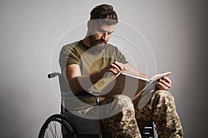 Ex-serviceman sitting in a wheelchair and reading a book