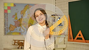 exact sciences. measure angles in degrees. Small child girl holding school protractor for geometry lesson. Learning to