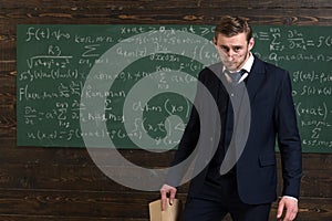 Exacting teacher. Teacher formal wear and glasses looks smart, chalkboard background. Professor exacting and strict